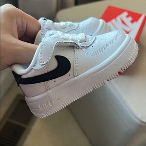 Air Force Ones 
Nike Kids White Sneakers with Black Swoosh